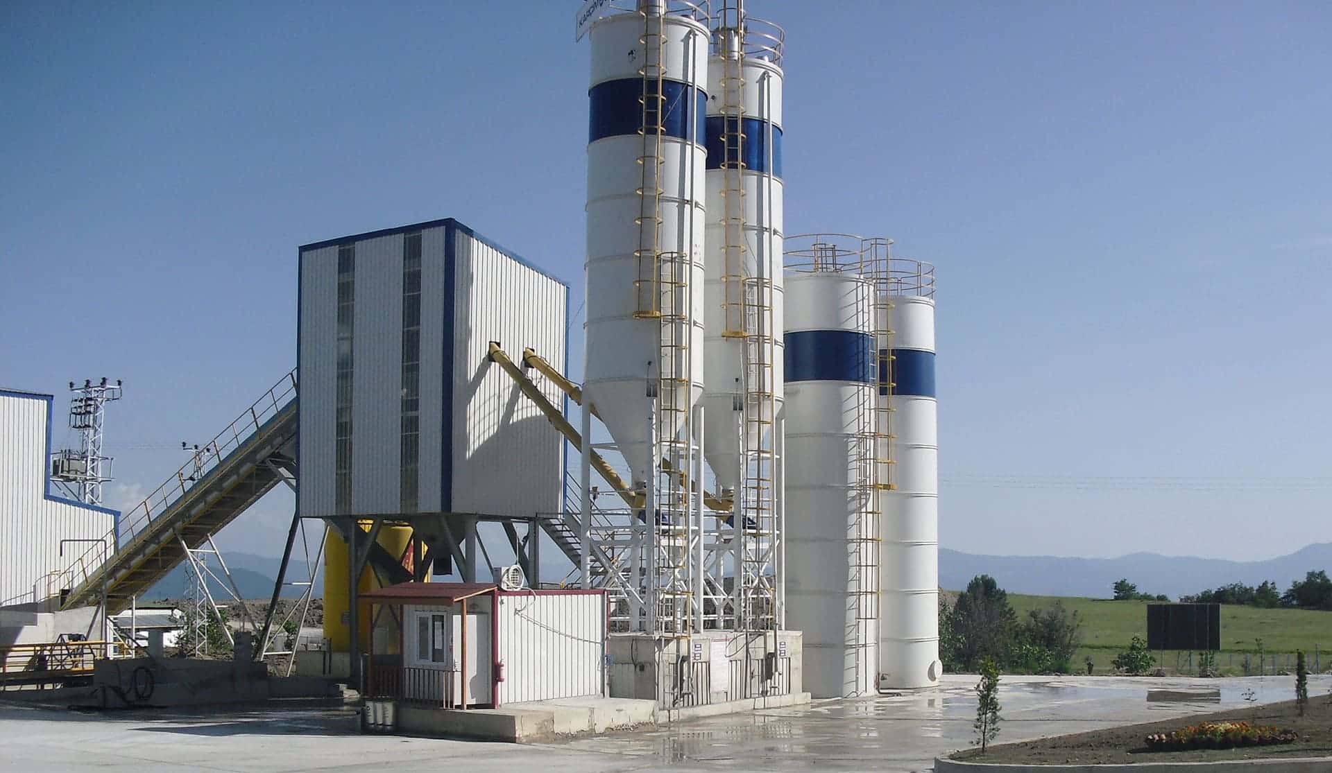 Açık alanda konumlanmış modern çimento fabrikası ve dikey silo yapıları